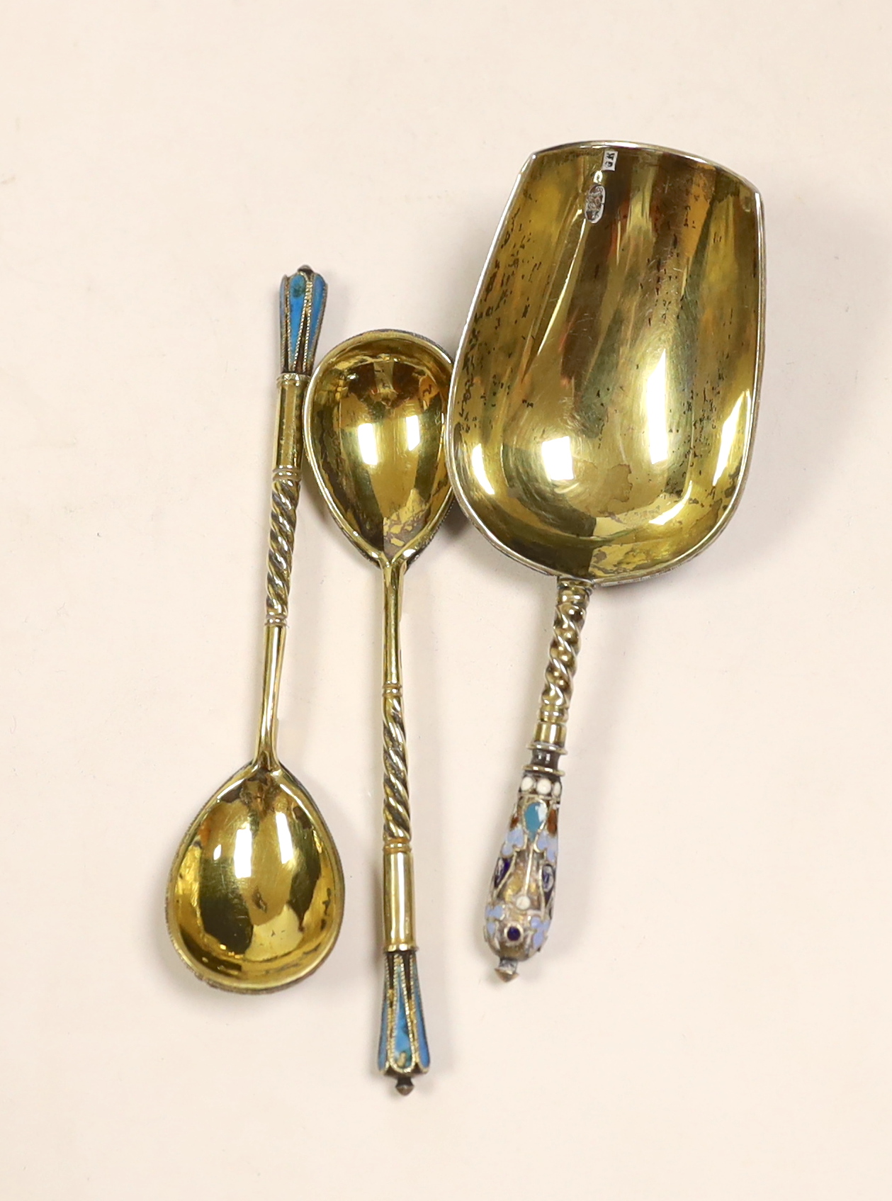 A late 19th century Russian 84 zolotnik and polychrome cloisonné enamel shovel shaped spoon, assay master Anatoly Artsibashov?, Moscow, 1891, 10.6cm, two later Russian similar coffee spoons and a cased 1911 commemorative